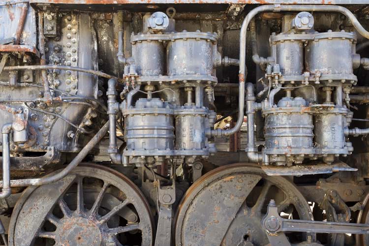 Details of an old steam train engine with rust and damage